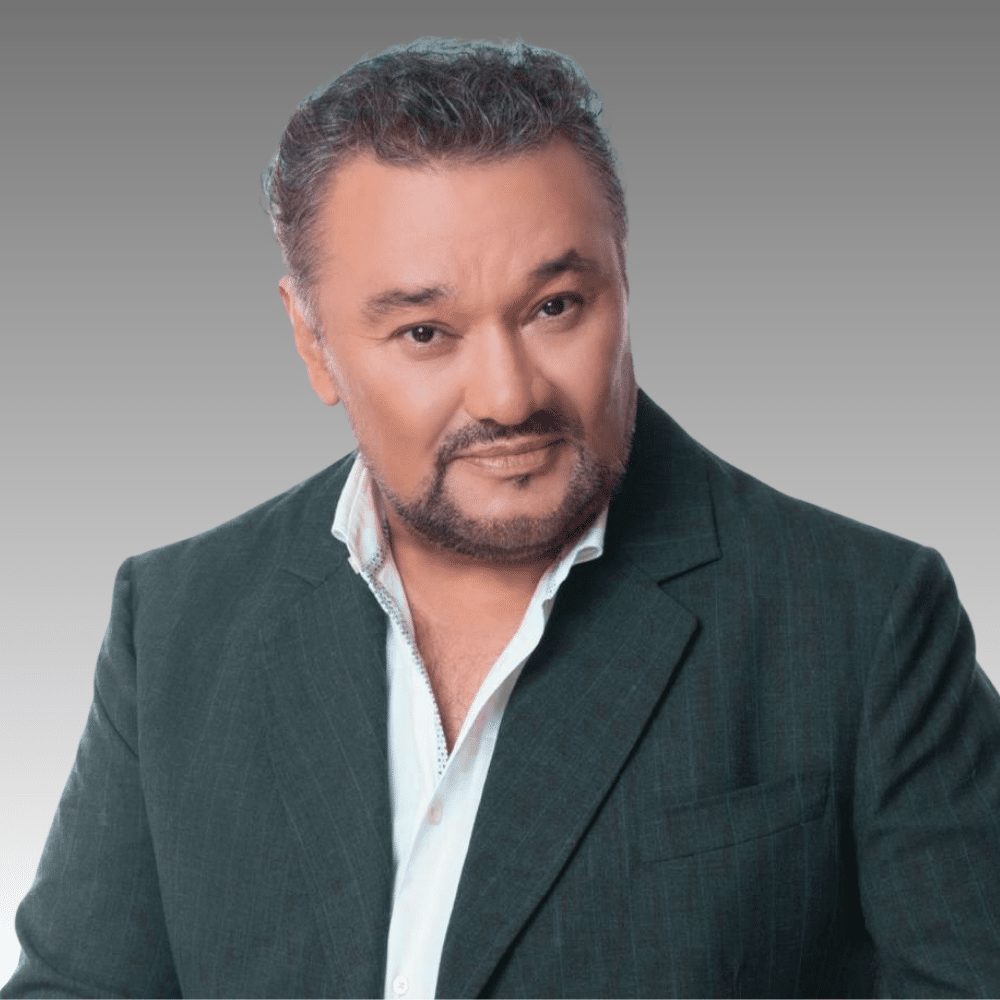 Portrait of a man with a goatee wearing a dark blazer and white shirt.